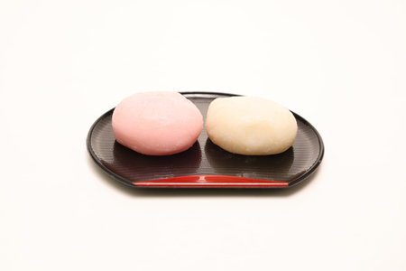 Pink and white rice cake on a plate isolated on a white background.の写真素材