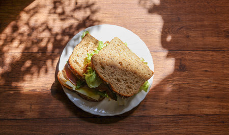 Organic sandwich on a plate isolated on a wooden background.