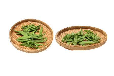 Field peas on a bamboo colander isolated on a white background.