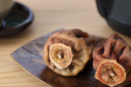 Dried persimmon on a plate on the wooden table.の写真素材