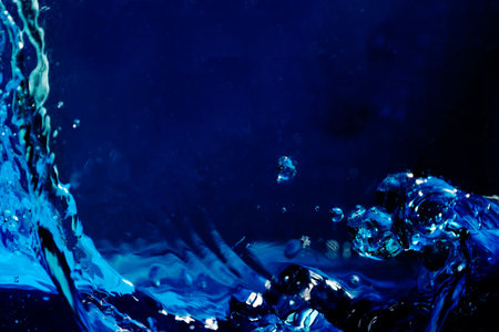 blue water splash with bubbles on dark blue background. abstract background.