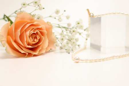Pearl necklace and bouquet of roses and baby's breath isolated on a white background.の写真素材