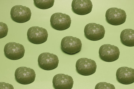 Many japanese riceâflour dumpling mixed with mugwort set in a green background.の写真素材