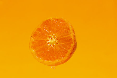 Half cut mandarin oranges isolated on a orange background.の写真素材