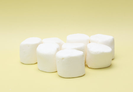 white marshmallows on yellow background, close-up, macroの写真素材