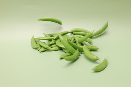 Snap peas isolated on a green background.の写真素材