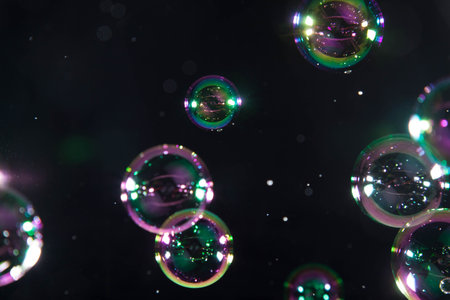 Soap bubbles with reflection on black background. Shallow depth of field.