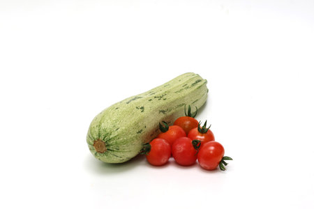 Zucchinis and grape tomatoes in a white background.の写真素材