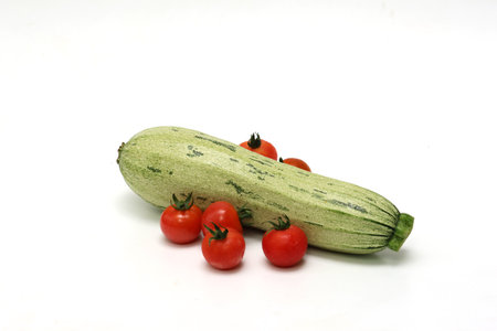 Zucchinis and grape tomatoes in a white background.の写真素材