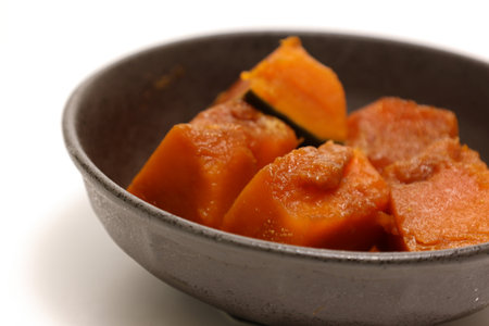 Boiled pumpkin with soy sauce and dashi in a crockery isolated on a white background.の写真素材