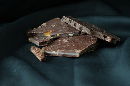 Orange flavor chocolates isolated on a black cloth background.
