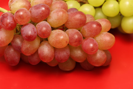 Close-up picture of grape and muscat on a red background.の写真素材