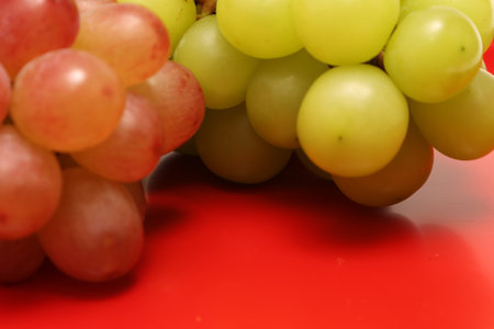 Close-up picture of grape and muscat on a red background.の写真素材
