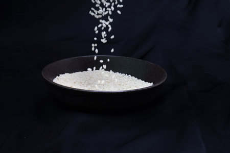 Sticky rice in a bowl isolated on a black background.の写真素材