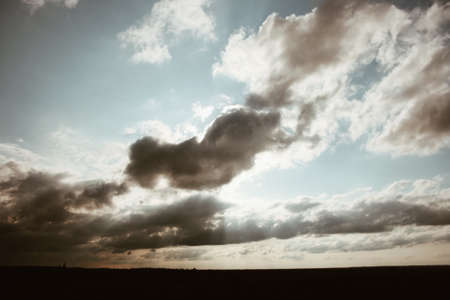 Beautiful sunset over a green pine forest. Sun through the clouds.の写真素材