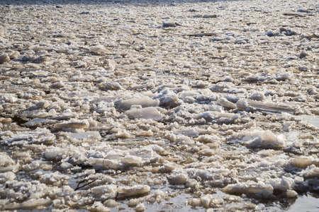 cracked ice floating springtime on blue water mountain lake, seasonal winter landscape