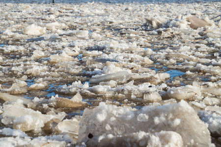 cracked ice floating springtime on blue water mountain lake, seasonal winter landscapeの写真素材