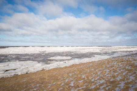 Sea shore with blue skies and pushed ice cubes.の写真素材