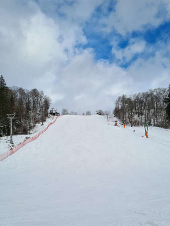 Ski resort in beautiful winter day. ski tracks, pine tree forest and mountains in the background. Winter holidays in Europe. downhillの写真素材