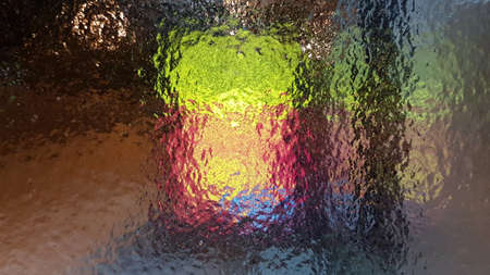 colored ice background. Winter ice frosted glass through which shines are colored. Pattern texture