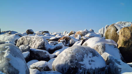 pile of snowy rocks in the winter mountains on a sunny winter day with a blue sky. Winter landscapeの写真素材