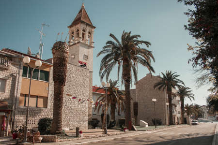 Narrow old streets and courtyards in Croatia, a medieval area with huge palm trees and a building...