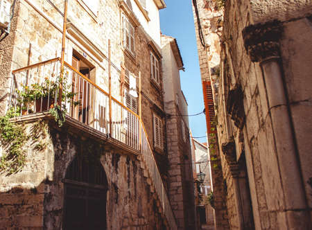 Beautiful street with flowers in the Hvar town, Hvar island, Dalmatia, Croatia. Old Mediterranean street, Hvar town. Old Adriatic town Hvar. Medieval street. Popular touristic destination of Croatia. street viewの写真素材