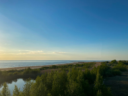 Aerial shot. Sea shore with green bushes in the summer evening with a sunset sky.の写真素材