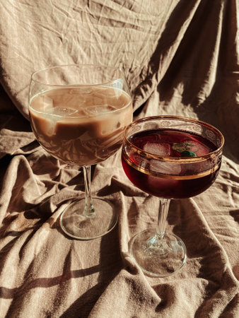 Soft drinks in glasses. Iced coffee and red juice in a glass glass on a background of beige cloth.の写真素材