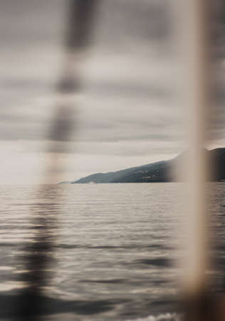 View of the Croatian mountains through the sailing ropes of ships. cloudy dayの写真素材
