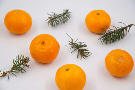 Christmas composition. Pattern made of pine branches and mandarins on light background. Flat lay,...