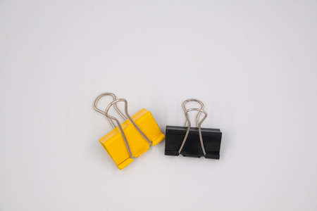 Yellow and black Paper clip isolated on white background.