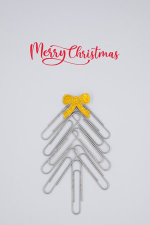 Concept merry xmas in the office. Xmas tree made of paper clips on the white background. paper clip Christmas tree. Christmas background.の写真素材