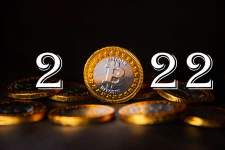 2022 year Cryptocurrency financial concept. Golden bitcoin and number 2022 on pile of coin. Copy space.の写真素材
