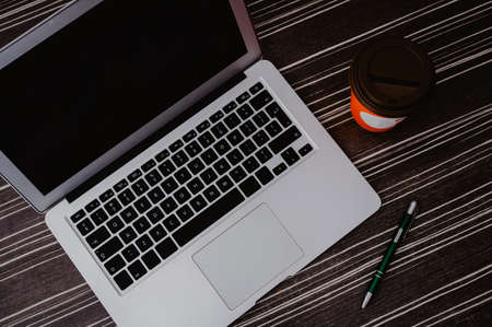 Flat lay, top view office table desk. Workspace with, laptop, pen, and coffee cup on wood...