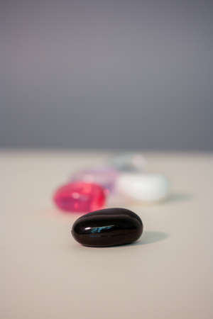 close-up of a black glass stone on a white background with colored stones in the background.Product photoの写真素材