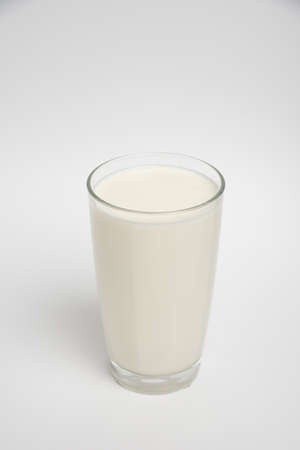 Milk glass closeup on white backgroundの写真素材
