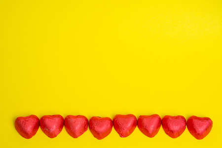 Chocolate Candy Red Heart Sweets for Valentine's Day on yellow background.Copy space