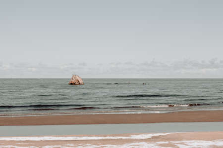 Seaside landscape in early spring day with remnants of snow in the sea sand. A washed-out shipwreck can be seen on the shore.の写真素材