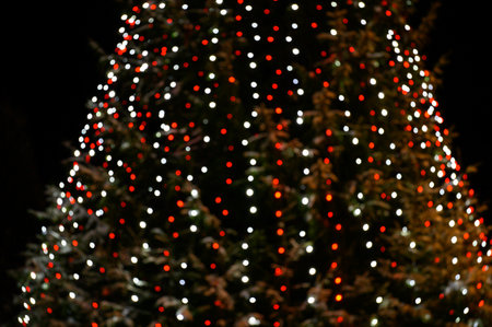 Abstract christmas background with christmas tree with decorations, defocused bokeh lights outdoors.
