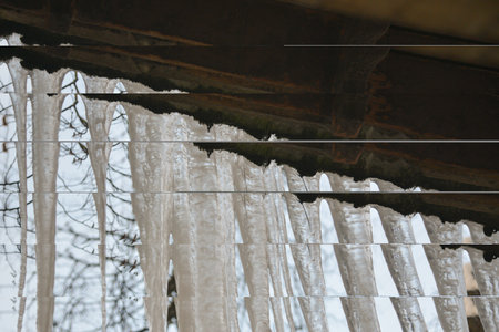 Icicles hanging from the roof against the sky