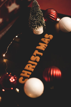Gingerbread words Merry Christmas on old black table with Christmas decorationsの写真素材