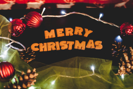 Gingerbread words Merry Christmas on old black table with Christmas decorationsの写真素材