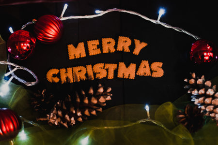 Gingerbread words Merry Christmas on old black table with Christmas decorationsの写真素材