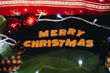 Gingerbread words Merry Christmas on old black table with Christmas decorationsの写真素材
