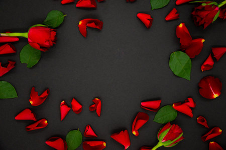 pile of bright red rose petalson a black backgroundの写真素材