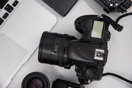 top view of work space photographer with digital camera, flash, cleaning kit, memory card, external...