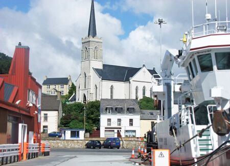 Church between Large fishing trawlers at Killybegs Harbour Coaの写真素材