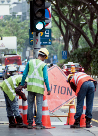 Foreign workers engaging in road work in Singaporeのeditorial素材