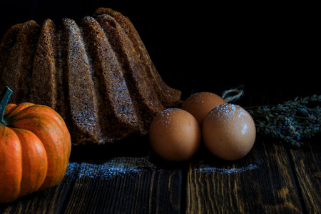 cake, egg and pumpkin on wooden background concept photo shootの写真素材